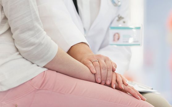 Doctor putting her hand on a patient
