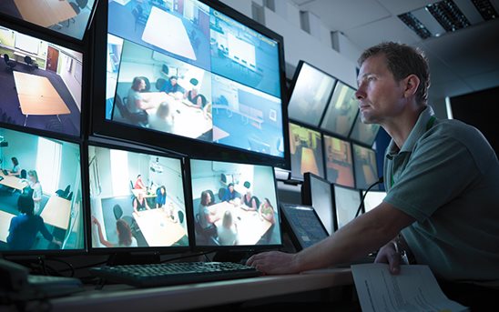 Man looking at multiple monitor screens