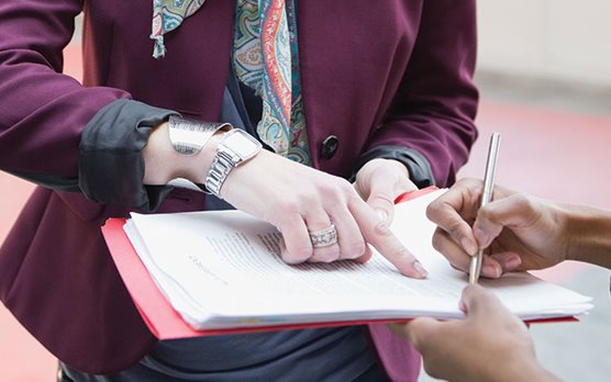 Woman pointing where to sign document