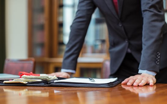 Man leaning on desk with his hands